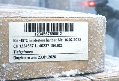 Tiefkühlkennzeichnung auf einem gefrorenen Paket mit Barcodeetikett im Kühl- oder Tiefkühllager, geeignet für niedrige Temperaturen und feuchte Oberflächen.